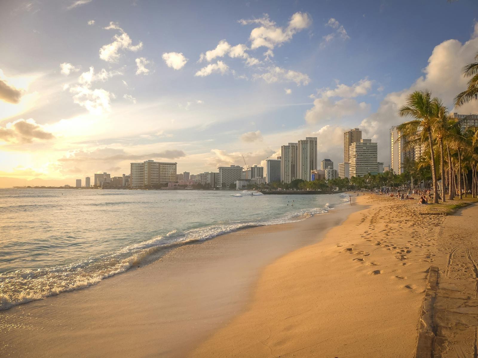 Experience the serene beauty of Honolulu's beach at sunset, featuring the city's stunning skyline.