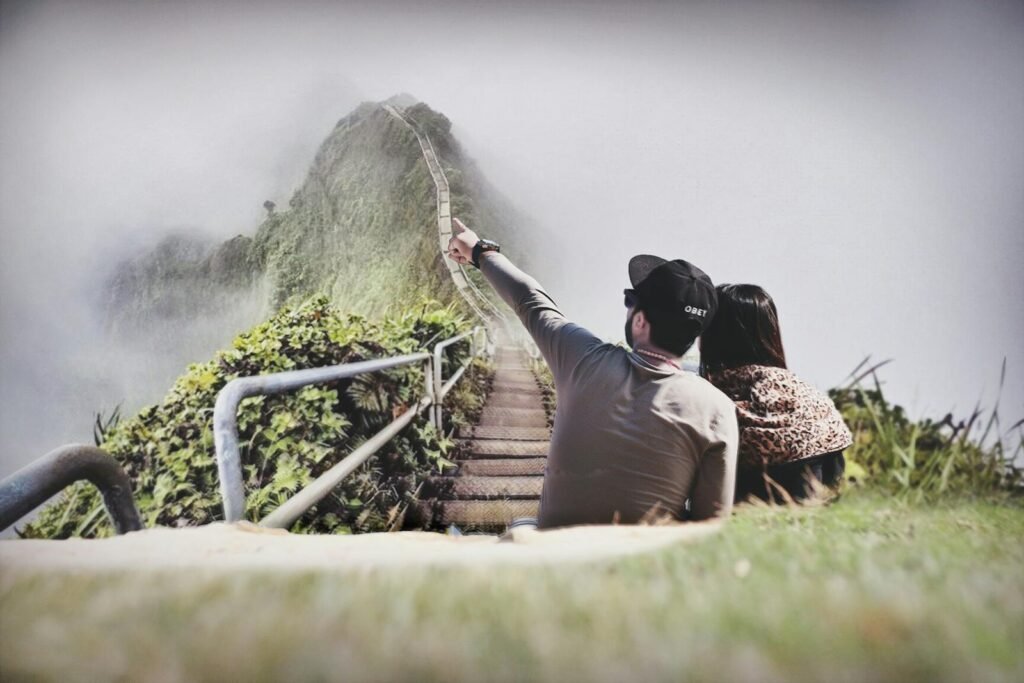 A young couple enjoys the scenic view from a foggy mountain stairway, embracing nature's beauty.